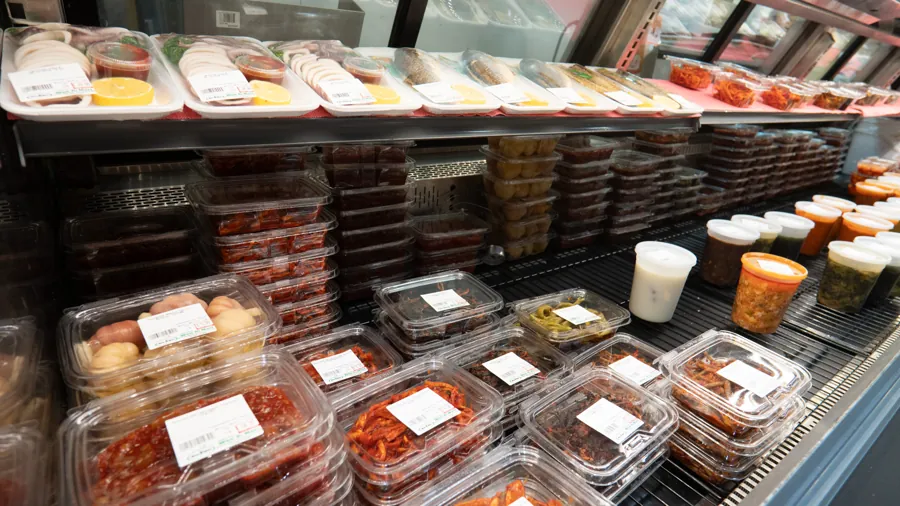 Containers of freshly made banchan and kimchi in the refrigerated case at Woo-Ri Mart